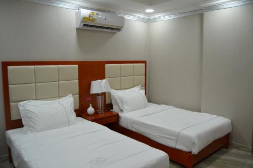 Säng eller sängar i ett rum på بروج السالمية للشقق المخدومة Brouj Al salmiya apartments Serviced