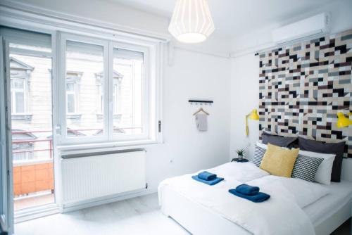 ブダペストにあるCentral new home with 3 bedrooms, A/C and balconyの白いベッドルーム(大きな窓、ベッド付)