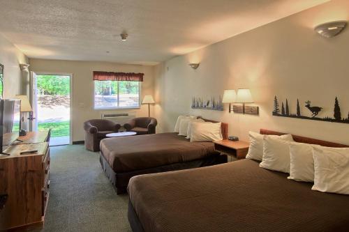 a hotel room with two beds and a couch at The Legend Cottage Inn in Bellaire