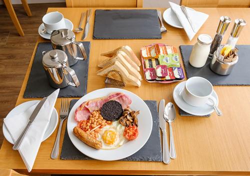 una mesa de madera con un plato de desayuno en Eastdene Guest House, en Inverness
