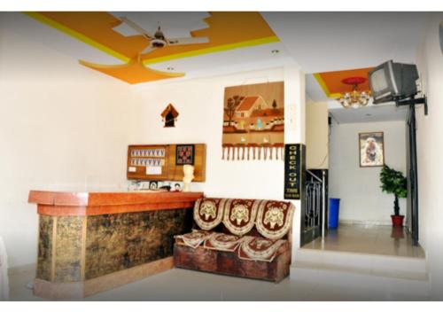 een lobby met een bar met een bank en een tv bij Hotel Arihant in Pachmarhī