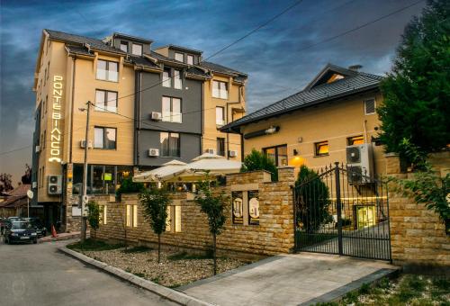 a large building with a fence in front of it at Hotel & Restaurant Ponte Bianco in Vranje