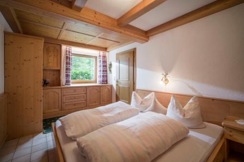 een slaapkamer met een bed met witte lakens en een raam bij Haus Sageler in Tux