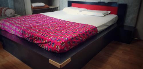 a bed with a red blanket on top of it at Hotel Ravi Mayur International in Chitradurga