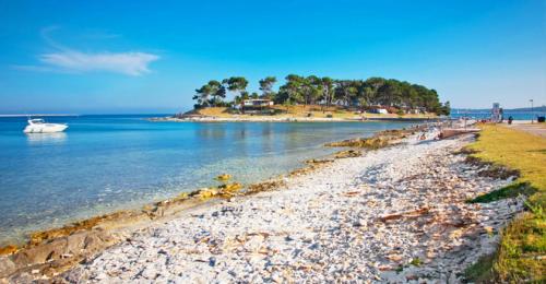 a beach with a boat in the water at Bed & breakfast La Fontana Medulin in Medulin
