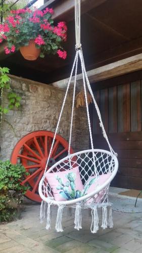a swing hanging from a porch with flowers at B&B Casa Zia Cianetta Residenza di Campagna in Capodacqua di Foligno