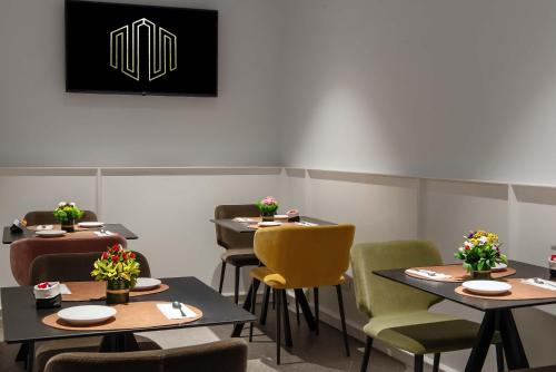 a dining room with tables and yellow chairs at Navona Street Hotel in Rome