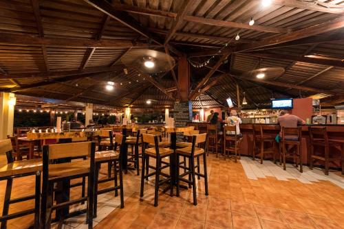un restaurante con mesas y sillas de madera y un bar en Hotel Rip Jack Inn, en Playa Grande