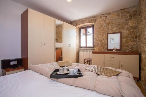 a bedroom with a large bed and a stone wall at Nona Nina in Vižinada
