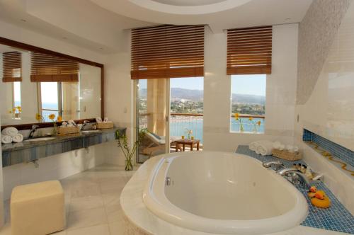 a large bathroom with a tub and a view of the ocean at Thalassa Boutique Hotel & Spa in Coral Bay