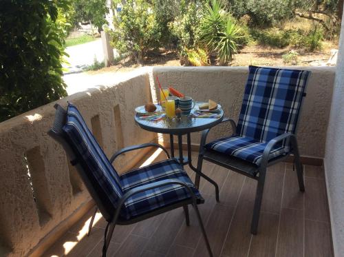 dwa krzesła i mały stolik na balkonie w obiekcie Elena Rooms w mieście Plakias