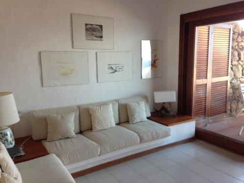 a living room with a white couch and a window at Villaggio Est a Capo Coda Cavallo San Teodoro in San Teodoro