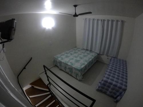 een kleine kamer met een bed en een trap bij Recanto Duas Peras in Caraguatatuba