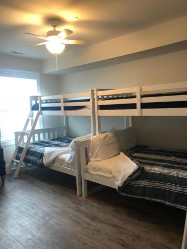 two bunk beds in a room with a ceiling fan at Ocean Manor 1100 Inn in Ocean City