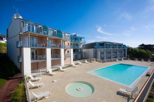 une vue aérienne d'un immeuble avec piscine dans l'établissement Residence Le Phare de Trescadec - maeva Home, à Audierne