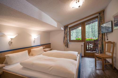 a bedroom with a white bed and a window at Ferienhaus Regina in Tux