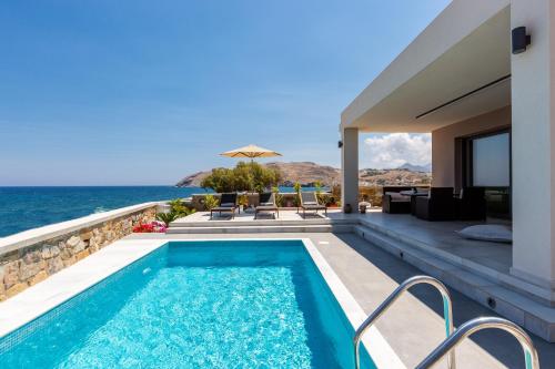 a swimming pool with a view of the ocean at Ethereal Villa in Panormos Rethymno