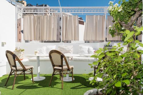 a patio with two chairs and a table in the grass at The Town House in Marbella