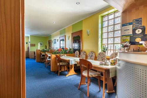 uma sala de jantar com mesas e cadeiras num restaurante em City Hotel Hilden em Hilden