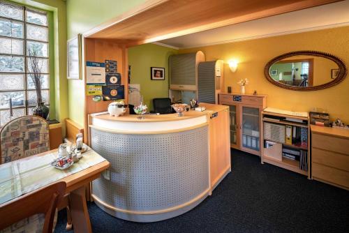 a bar in a room with a counter and a mirror at City Hotel Hilden in Hilden