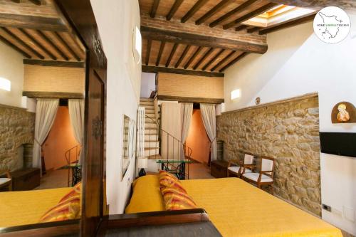 1 dormitorio con cama y pared de piedra en Casa Scuderia en Volterra