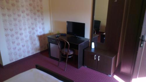 a room with a desk with a television and a chair at Rooms Villa Iva in Ilok