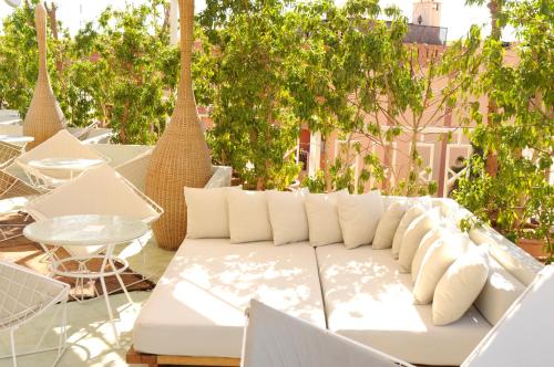 a white couch sitting on a patio with trees at Bab Hotel in Marrakech