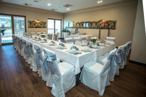 a room with a long table with white tables and chairs at Hotel Rondo in Wąbrzeźno