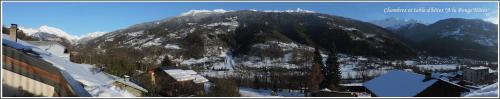 a mountain covered in snow with houses and buildings at A la Bouge'Hôtes in Bellentre