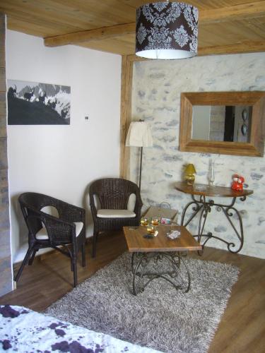 a living room with chairs and a table and a mirror at A la Bouge'Hôtes in Bellentre