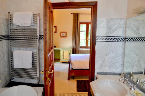 a bathroom with a sink and a bed in a room at Castello Delle Serre in Rapolano Terme