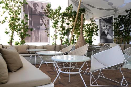 a room with tables and chairs and a couch at Bab Hotel in Marrakech