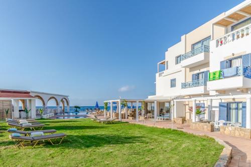 a building with benches and the ocean in the background at Pyrgos Blue in Malia