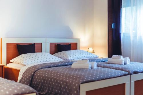 two beds in a room with towels on them at Music Time Apartment in Imotski
