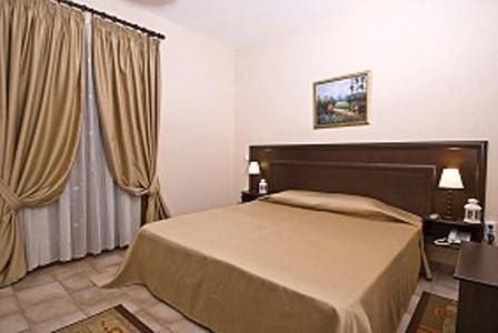 a bedroom with a bed and a large window at Hotel Kapsalis in Veria