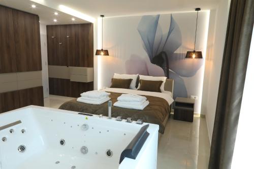a bathroom with a bath tub and a bed at Princ Apartment in Niš