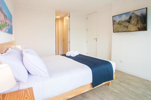 1 dormitorio con 1 cama blanca grande con almohadas blancas en Lima Walking Apartments - Central Miraflores, en Lima