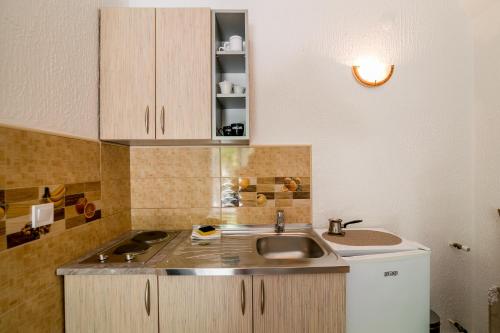 uma pequena cozinha com um lavatório e um balcão em Apartmani Stefanovic em Herceg Novi