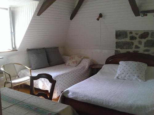 a small room with two beds and a chair at Auberge Hôtel de Tournemire - Cantal in Tournemire