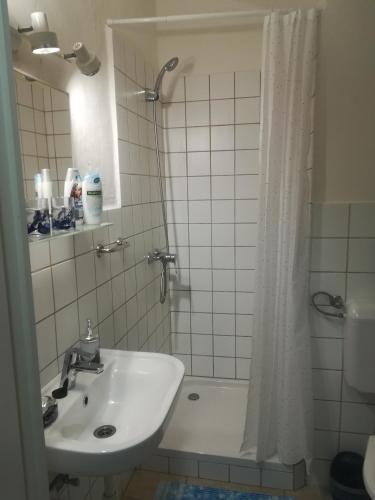a bathroom with a sink and a shower with a shower curtain at Apartman Bécsi utca in Sopron
