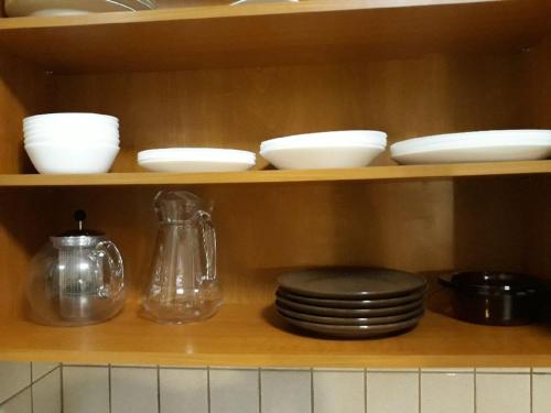 a shelf with plates and utensils in a kitchen at Apartament Park in Słupsk