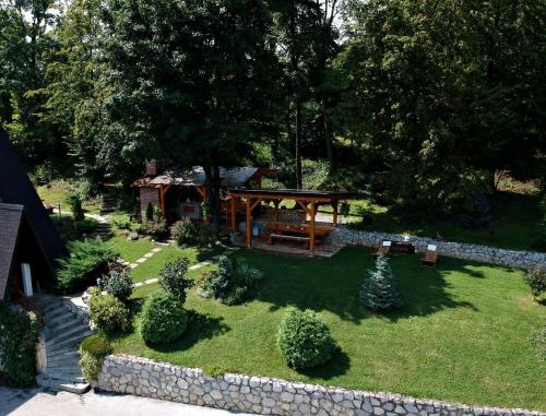 a garden with a picnic table and a stone wall at Kuća za odmor Bitoševje in Klenovnik