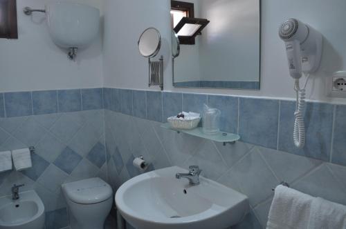 une salle de bain avec un lavabo, des toilettes et un miroir dans l'établissement Il Palombaro, à Tropea