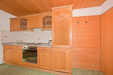 eine Küche mit Holzschränken und einem Herd in der Unterkunft Alpenhof Klais in Klais