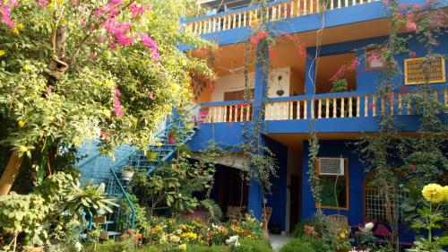 a blue building with flowers in front of it at The Coral Tree Boutique Homestay in Agra