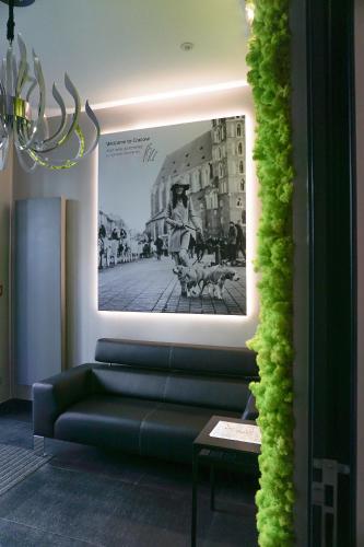 a living room with a couch and a picture on the wall at AGA Tenis Apartments by Radwańska in Krakow