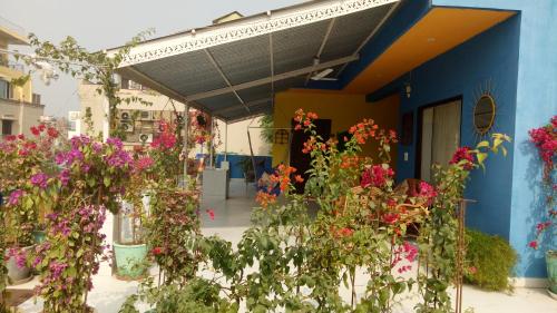 a blue building with flowers in front of it at The Coral Tree Boutique Homestay in Agra