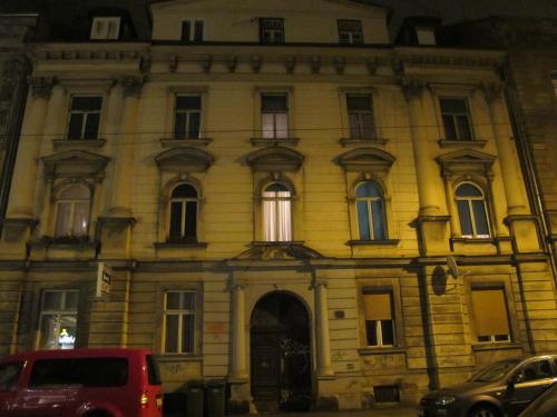 Centar Guesthouse في زغرب: مبنى قديم تقف أمامه شاحنة حمراء