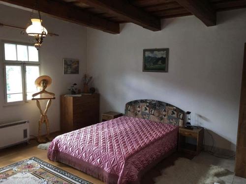 1 dormitorio con 1 cama con edredón morado en Chalupa Matej, en Liptovská Osada
