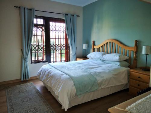 una camera da letto con un letto grande e una finestra di Lemon Tree Cottage a Edgemead